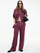 Conjunto de camisa de manga larga y pantalón de vestir a rayas verticales color borgoña con detalles en blanco.