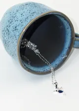 Collar de plata 925 con dije de colibrí adornado con zirconias blancas y una zirconia azul en forma de lágrima. La cadena mide 40 o 45 cm.