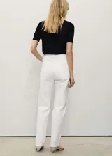 Pantalón de jean blanco, de corte recto, con tiro medio, cinco bolsillos y cierre frontal con cremallera y botón.