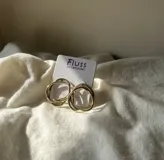 Aritos de bronce hechos a mano con diseño entrelazado, añadiendo un toque elegante.