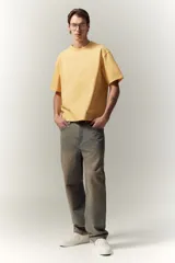 Remera de algodón color amarillo, de corte holgado, con cuello redondo ribeteado, hombros caídos y bajo recto.