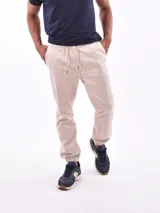 Pantalón jogger color beige con cintura elástica ajustable con cordón y tobillos ajustados.