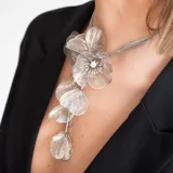 Collar de acero inoxidable con diseño floral, disponible en dorado y plateado, con medidas ajustables.
