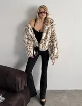 Tapado corto de piel sintética con estampado animal print, corte recto, largo a la cadera, interior forrado y ganchos internos para cerrar.