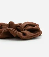 Coletero scrunchie de tela texturizada color marrón con lazo.