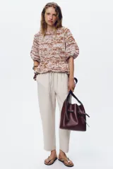 Pantalón tobillero negro con cintura elástica ajustable con cordones, bolsillos delanteros y falsos bolsillos con solapa en la espalda.