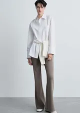 Pantalón acampanado color gris topo, de tejido de punto con cintura elástica y tiro medio.