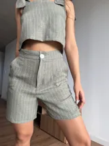 Short verde con finas rayas verticales blancas, de tela sastrera sin elasticidad.