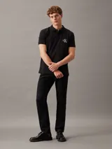 Chomba negra de piqué de algodón elástico, corte regular, con cuello clásico, tapeta de dos botones y logo bordado de Calvin Klein en el pecho.