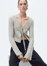 Pantalón negro de vestir, de tiro alto, corte recto y largo. Presenta cierre frontal con botón, gancho y cremallera oculta, trabillas, bolsillos laterales, pinzas delanteras, forro interior y bolsillo de ribete en la parte posterior.