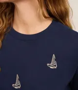 Blusa azul marino de algodón con cuello redondo y mangas cortas. Presenta bordados de barcos de vela en la parte delantera.