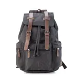 Mochila de tela canvas color verde oliva con tapa y detalles en símil cuero marrón. Cierre superior marinero, bolsillos internos, externos frontal, laterales y trasero con cierre. Asas rígidas, correas ajustables y espacio para laptop de 15".