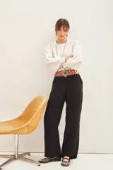 Pantalón palazzo de tiro alto, color negro, con caída fluida y largo al piso. Confeccionado en cupro y viscosa, presenta bolsillos laterales.