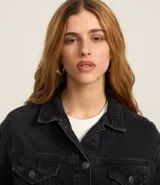 Campera boxy de jeans azul, con cuello clásico, cierre frontal con botones, bolsillos con solapas abotonadas en el pecho y recortes.