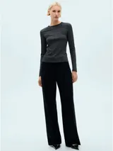 Remera negra con brillo, de tejido de punto fino y manga larga.