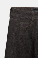 Jeans de tiro medio, color negro lavado con efecto desgastado, corte recto y holgado (loose straight), con cinco bolsillos y cierre frontal de cremallera y botón.