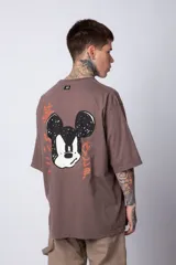 Remera blanca de algodón de corte oversize con mangas cortas y cuello redondo. Presenta un pequeño estampado en el frente con la figura de Mickey Mouse y caracteres orientales.