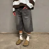 Bermuda gris oscuro de jean, corte ancho a la rodilla.