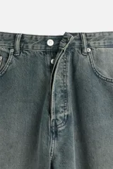 Pantalón de jean negro de corte amplio, con cinco bolsillos, efecto lavado y cierre frontal con cremallera y botón.