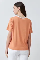 Remera de manga corta con diseño color block en crudo, blanco y negro.