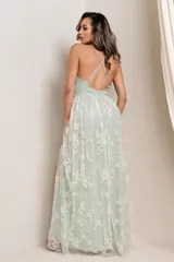 Vestido largo de fiesta color champagne, con escote en V profundo, breteles finos y falda con abertura lateral. El vestido está confeccionado en tul bordado con flores y lentejuelas.