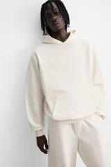 Sudadera con capucha gris confeccionada en tejido de algodón con interior rizo. Tiene manga larga, bolsillo frontal tipo canguro y acabados en rib.
