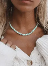 Collar corto con cuentas de cristal checo en forma de disco y cuentas cuadradas de cerámica en color turquesa y blanco. Cierre de acero.