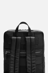 Mochila marrón de cuero sintético con textura grabada. Tiene un compartimento principal con cierre de cremallera, un bolsillo interno para dispositivos electrónicos de hasta 13 pulgadas y un bolsillo interno con cremallera. En la parte delantera tiene un bolsillo con cremallera. La parte posterior es acolchada y tiene una banda de sujeción para equipaje. Tiene un asa de mano y dos asas de hombro ajustables y acolchadas.