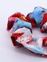 Colero de tela con estampado abstracto en tonos rojo, azul y blanco.