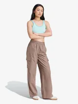 Pantalón cargo Adidas color marrón topo, de corte holgado con cintura elástica ajustable, bolsillos laterales con solapa y las tres tiras características de la marca en color blanco.