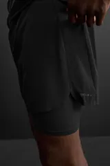 Shorts de running negros con malla interior, cintura elástica ajustable con cordón, bolsillo trasero con cierre, bolsillo multifunción en la malla interior, perneras perforadas, bajo termofijado, aberturas laterales y logo estampado.