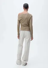 Camiseta color beige con textura, cuello asimétrico y manga larga. Diseño entallado.