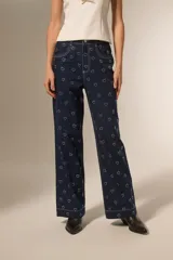 Pantalón de jean azul oscuro con estampado de corazones blancos, corte ancho y tiro alto.