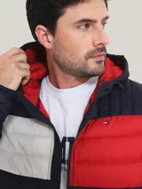 Campera acolchada Tommy Hilfiger, con capucha y cierre frontal. Diseño color block en azul marino, blanco y rojo.