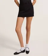 Short pollera negro de bengalina con cintura fija, trabillas, cierre tradicional y frisos.