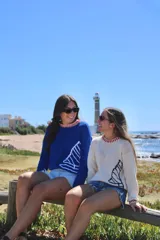 Sweater tejido a mano en lana merino o hilo de algodón, con cuello redondo y diseño de velero en el frente.