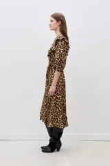 Vestido midi con estampado animal print de leopardo, escote en V cruzado, mangas 3/4 con volados en los hombros, cinturón negro con aplique de flor y volados en el ruedo.