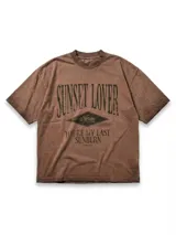 Remera de jersey con efecto teñido y corte holgado. Presenta una estampa frontal con el texto 'Sunset Lover' y 'You're my last sunburn' en color verde.