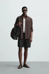 Bermuda negra de lino con calce relajado. Presenta cintura elástica ajustable con cordón, bolsillos frontales y un bolsillo trasero de plastrón.