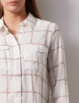 Camisa de gasa estampada, marca Tahari. Cuello a la base con solapa y apertura central con botones. Delantera con bolsillos aplicados. Manga larga con puño y botón.