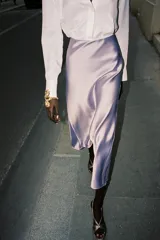 Falda midi color lila de satén, de tiro alto y cintura elástica.