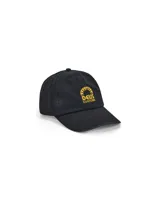 Gorra de béisbol negra con logo Deus Ex Machina bordado en dorado en el frente.