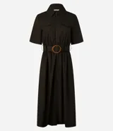 Vestido largo color verde oliva, de estructura sastrería confeccionado en tricolina. Tiene mangas cortas, cuello y cierre delantero por cremallera. Incluye cinturón de hebilla redonda con aspecto de madera.