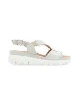 Sandalias de cuero color gris claro con tiras cruzadas y elástico. Suela de plataforma blanca.