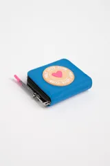 Billetera azul con diseño de corazón y cierre en cremallera, de dimensiones compactas.