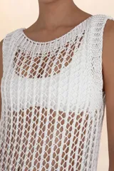 Vestido largo de crochet color blanco, sin mangas y con cuello redondo.