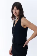 Chaleco corto negro con escote en V y cierre frontal con botones.