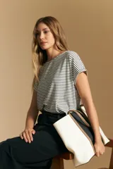 Remera de manga corta con cuello redondo, confeccionada en tejido acanalado a rayas horizontales blancas y negras.