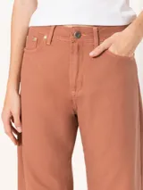 Pantalón color ladrillo de corte slouchy con cinco bolsillos y pinzas en las rodillas que estructuran la silueta con un aire urbano. Incluye metales en acabado níquel.