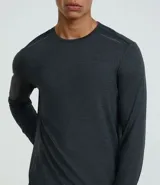 Remera deportiva de manga larga para hombre, color gris azulado jaspeado, con cuello redondo y costuras visibles en hombros y cuello.
